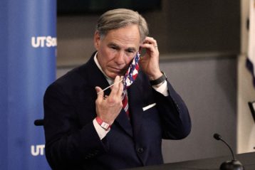 Texas governor Greg Abbott putting on face mask