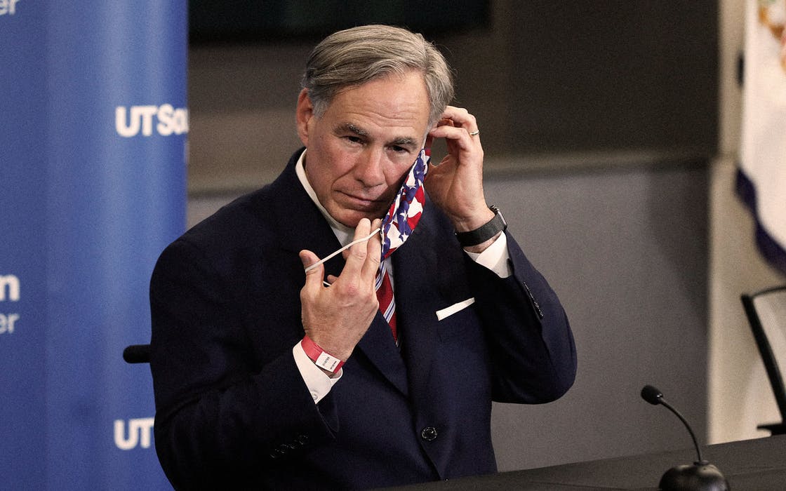 Texas governor Greg Abbott putting on face mask