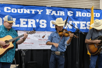 Fiddle player with two accompanists during Lea County Fair & Rodeo Fiddler's Contest in 2021