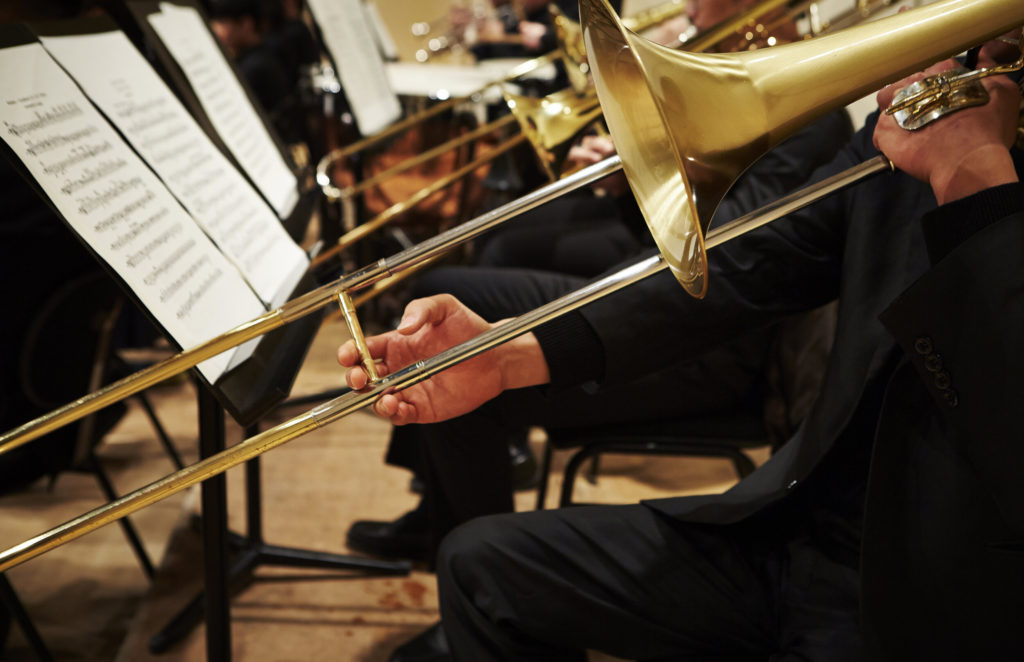Playing trombone with sheet music on stand